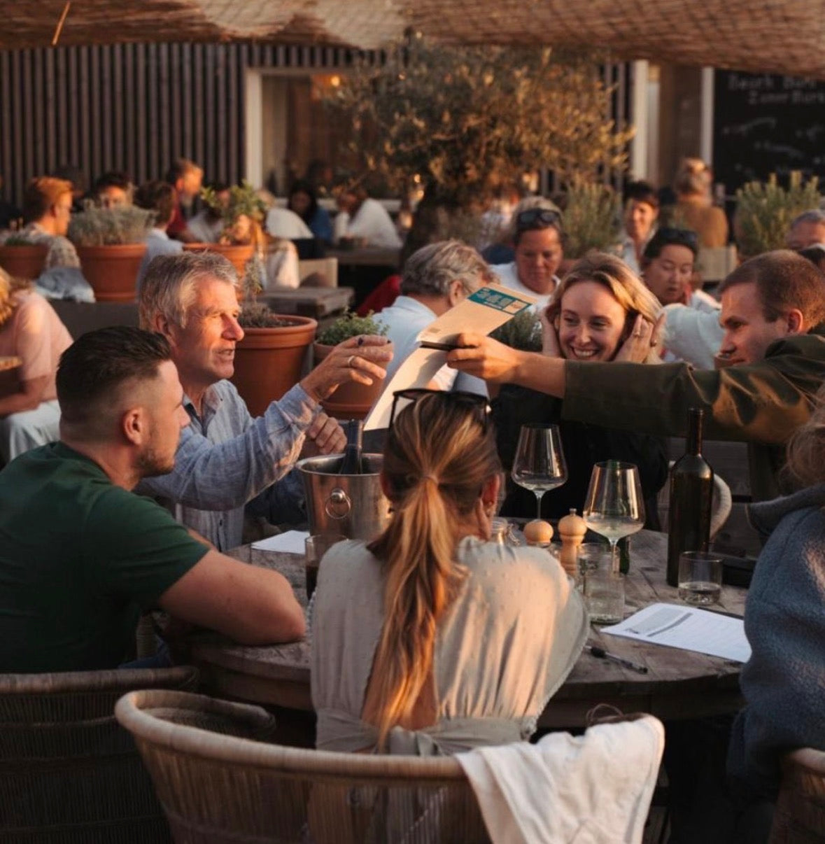 Gasten aan tafel op het terras van Beach Barn